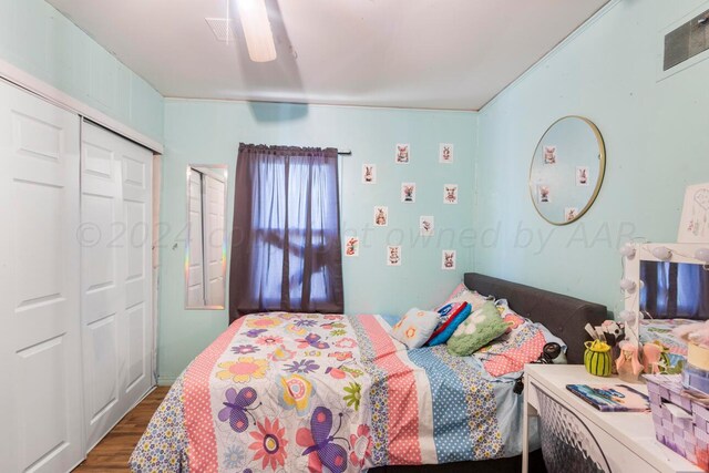 bedroom with dark hardwood / wood-style flooring, a closet, and ceiling fan