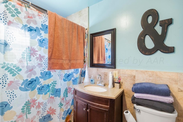 bathroom featuring vanity, toilet, and tile walls