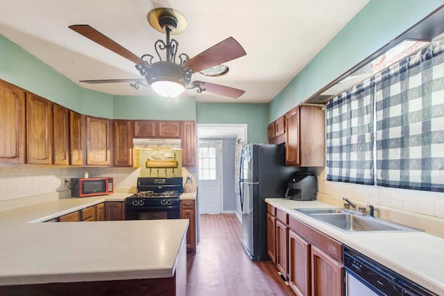 kitchen featuring black appliances, tasteful backsplash, dark hardwood / wood-style flooring, sink, and ceiling fan