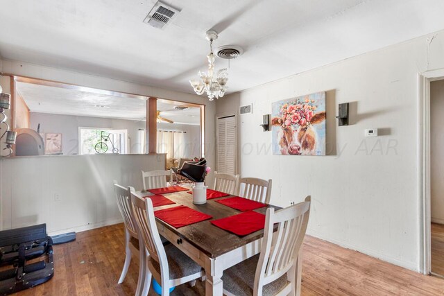 dining space with wood-type flooring and a chandelier