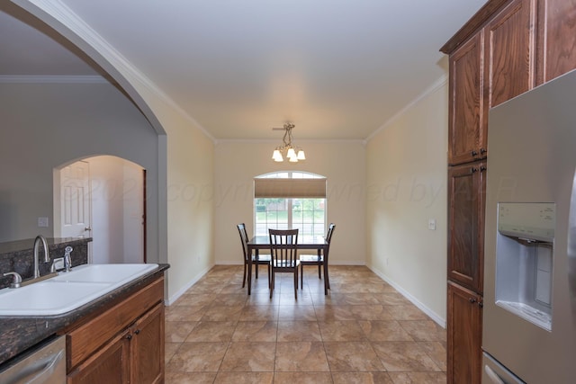 3508 Bismarck Ave, Amarillo, TX 79118 - dining room featuring ornamental molding, a chandelier, baseboards, and arched walkways