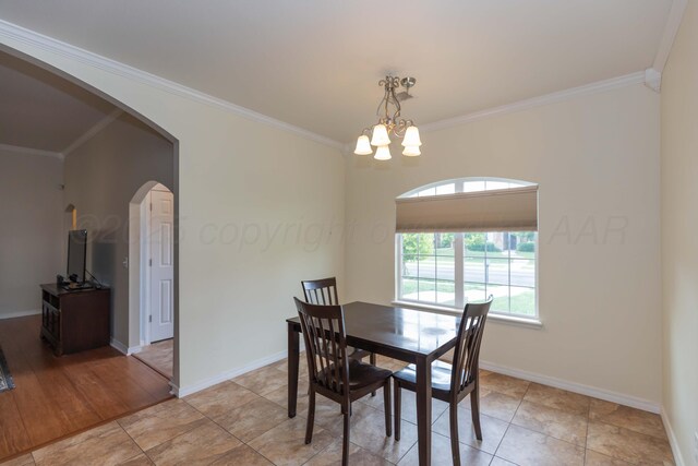 3508 Bismarck Ave, Amarillo, TX 79118 - dining space with arched walkways, ornamental molding, a chandelier, baseboards, and light tile patterned floors