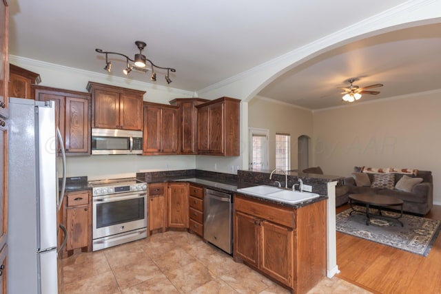 3508 Bismarck Ave, Amarillo, TX 79118 - kitchen featuring appliances with stainless steel finishes, arched walkways, open floor plan, a sink, and a peninsula