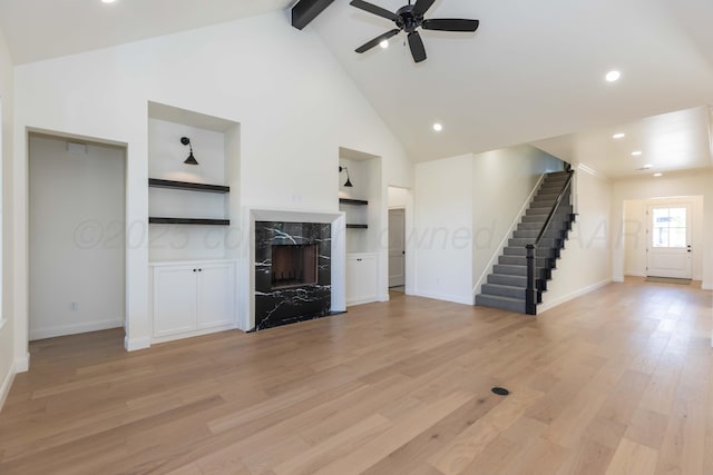 kitchen with a sink, premium range hood, white cabinets, stainless steel appliances, and light wood-style flooring