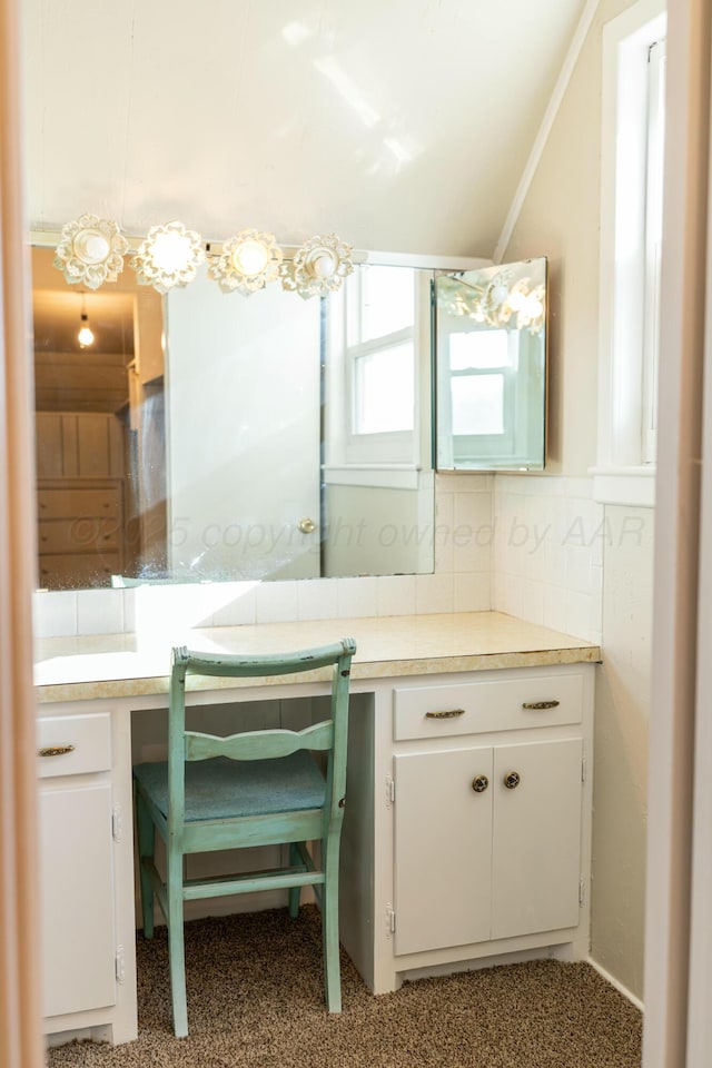 bathroom with lofted ceiling and backsplash