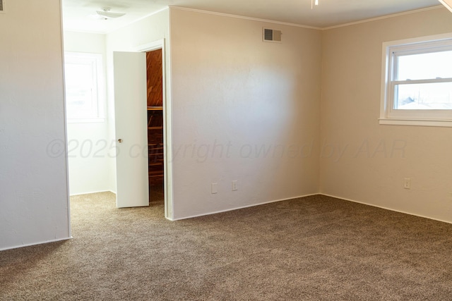unfurnished room featuring ornamental molding, carpet flooring, and visible vents