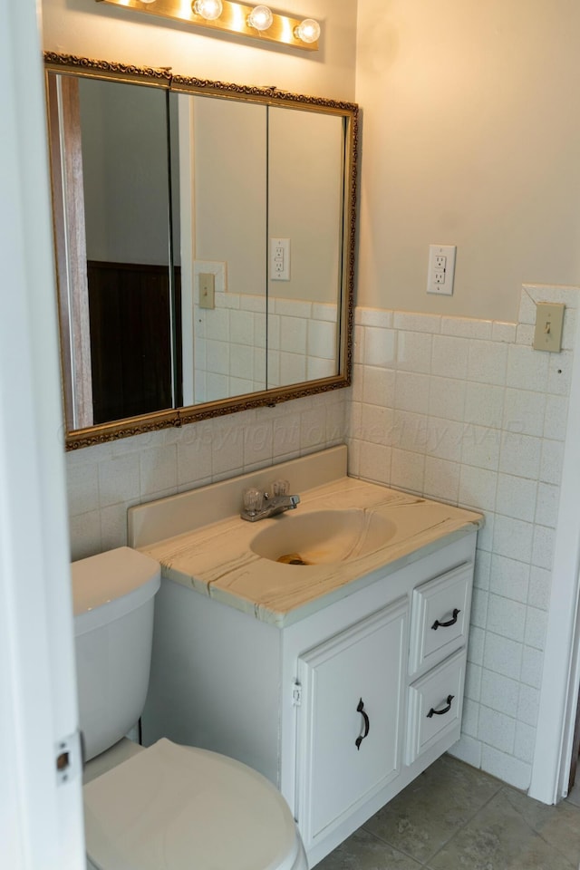 bathroom featuring vanity, tile walls, tile patterned floors, and toilet