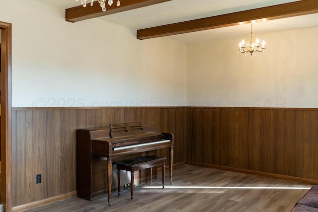 living area featuring dark hardwood / wood-style flooring, wooden walls, a chandelier, and beamed ceiling