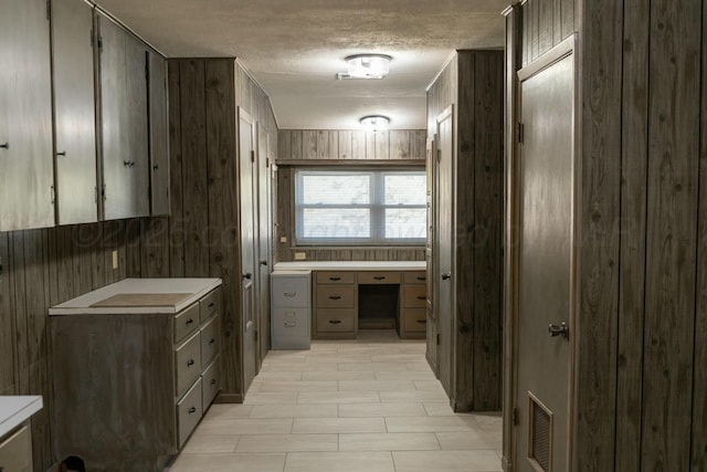 bathroom with a textured ceiling and wood walls