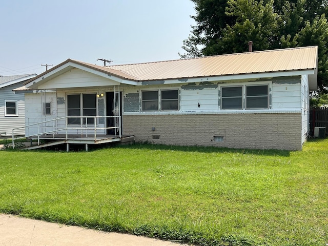 view of front facade with cooling unit and a front lawn