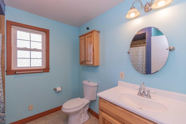 bathroom featuring toilet, baseboards, and vanity