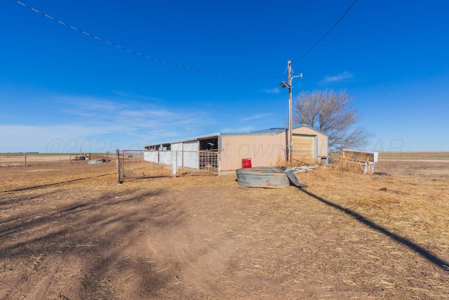 view of yard featuring a pole building, an outdoor structure, and fence