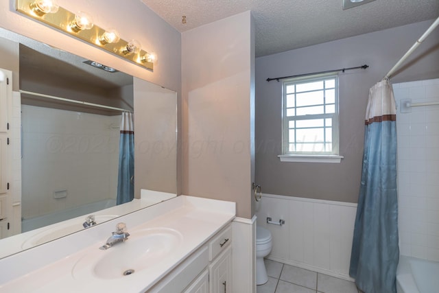 6111 Princeton St, Amarillo, TX 79109 - full bathroom with vanity, shower / tub combo with curtain, wainscoting, tile patterned floors, and a textured ceiling