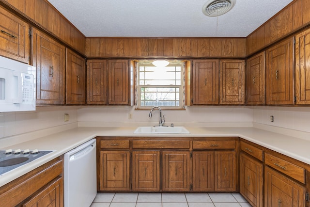 6111 Princeton St, Amarillo, TX 79109 - kitchen with white appliances, brown cabinetry, decorative backsplash, light countertops, and a textured ceiling
