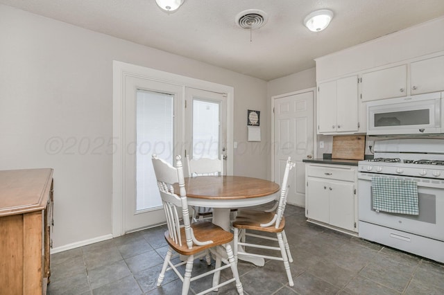 5222 S Travis St, Amarillo, TX 79110 - kitchen featuring white appliances, white cabinetry, and dark countertops