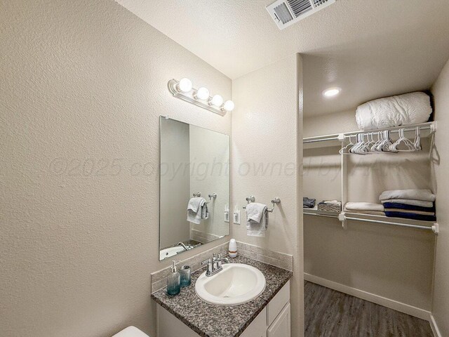 5012 Locker St, Amarillo, TX 79118 - bathroom featuring vanity, wood finished floors, and a textured wall