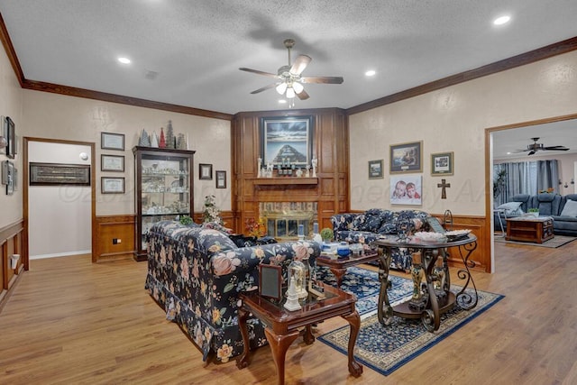 5105 Black Oak Dr, Amarillo, TX 79110 - living room with a ceiling fan, crown molding, a textured ceiling, light wood-type flooring, and wainscoting