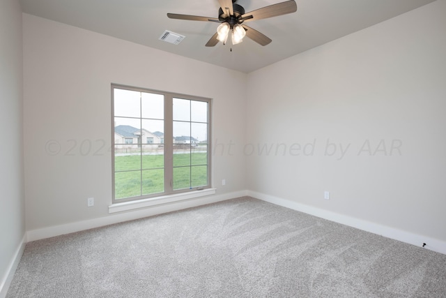 spare room with carpet floors, a ceiling fan, baseboards, and visible vents