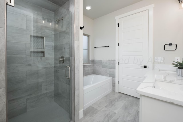 full bathroom featuring double vanity, a bath, a stall shower, a sink, and marble finish floor