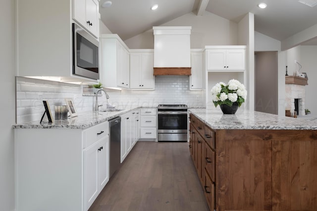 kitchen with stainless steel appliances, light stone countertops, dark wood finished floors, and a sink