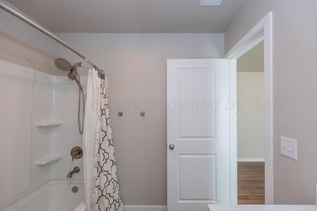 7701 Bellamy Dr, Amarillo, TX 79119 - bathroom with shower / bath combo with shower curtain and wood finished floors