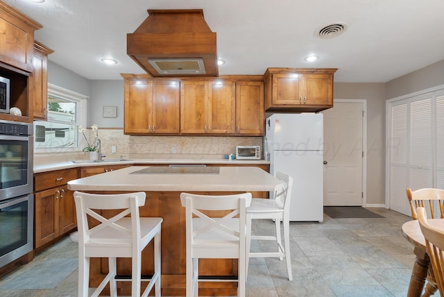 3607 Fleetwood Dr, Amarillo, TX 79109 - kitchen featuring freestanding refrigerator, double oven, light countertops, decorative backsplash, and recessed lighting