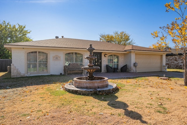 ranch-style home featuring a front lawn and a garage