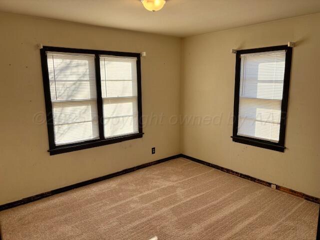 empty room with light carpet and baseboards