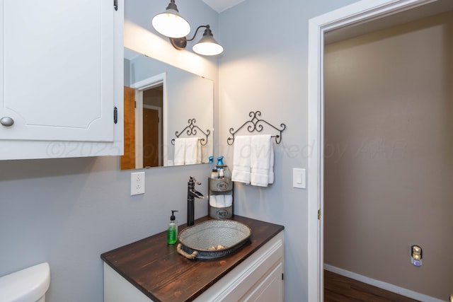 407 Thompson Ln, Canyon, TX 79015 - half bathroom featuring toilet, vanity, and wood finished floors