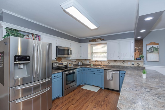 407 Thompson Ln, Canyon, TX 79015 - kitchen featuring a sink, crown molding, white cabinetry, blue cabinetry, and appliances with stainless steel finishes
