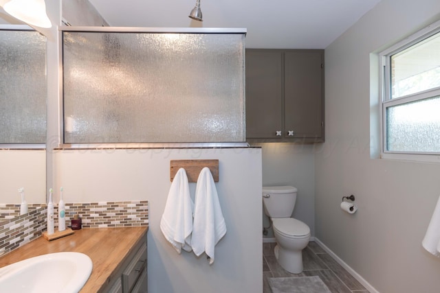 407 Thompson Ln, Canyon, TX 79015 - bathroom with a shower with door, vanity, toilet, and decorative backsplash