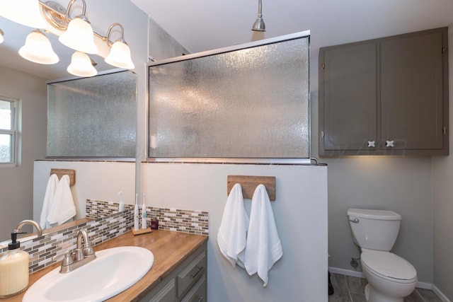 407 Thompson Ln, Canyon, TX 79015 - full bathroom featuring a shower with shower door, baseboards, toilet, vanity, and decorative backsplash