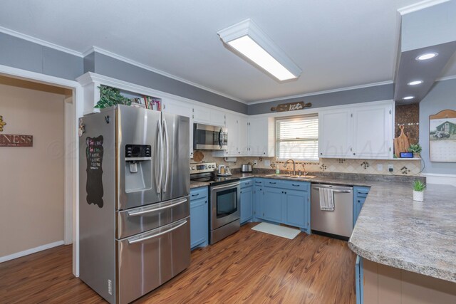 407 Thompson Ln, Canyon, TX 79015 - kitchen featuring a sink, stainless steel appliances, blue cabinets, ornamental molding, and white cabinets