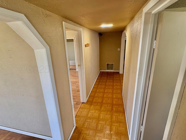 605 E 4th St, Panhandle, TX 79068 - corridor with a textured wall, a textured ceiling, and baseboards