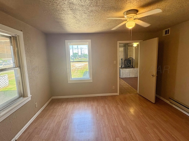 605 E 4th St, Panhandle, TX 79068 - unfurnished room featuring light wood finished floors, healthy amount of natural light, a textured ceiling, baseboards, and a ceiling fan