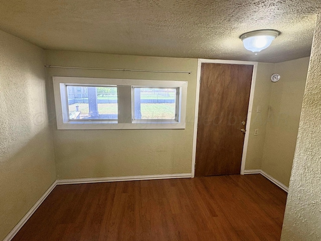 605 E 4th St, Panhandle, TX 79068 - spare room with wood finished floors, baseboards, a textured wall, and a textured ceiling