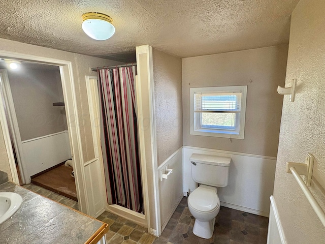 605 E 4th St, Panhandle, TX 79068 - bathroom with a textured ceiling, toilet, curtained shower, a textured wall, and vanity
