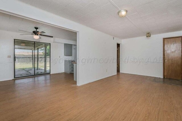empty room with wood finished floors and a ceiling fan