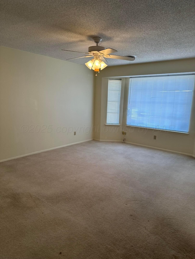 carpeted empty room with ceiling fan and a textured ceiling