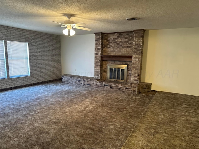 unfurnished living room featuring brick wall, a fireplace, carpet, and a textured ceiling