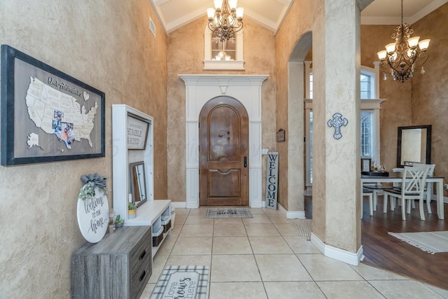 212 Cimarron St, Borger, TX 79007 - entryway featuring a chandelier, arched walkways, tile patterned floors, high vaulted ceiling, and baseboards