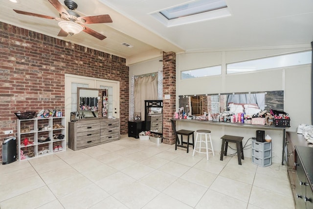 212 Cimarron St, Borger, TX 79007 - kitchen featuring brick wall, tile patterned flooring, a ceiling fan, and a breakfast bar
