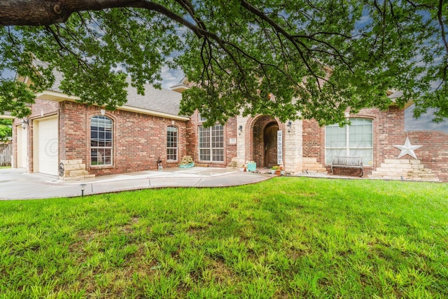212 Cimarron St, Borger, TX 79007 - view of front of house featuring a garage, a front lawn, brick siding, concrete driveway, and a patio