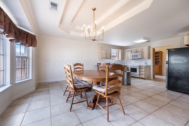 dining space featuring a tray ceiling, plenty of natural light, visible vents, and ornamental molding