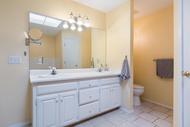 full bathroom with double vanity, a skylight, tile patterned floors, and a sink