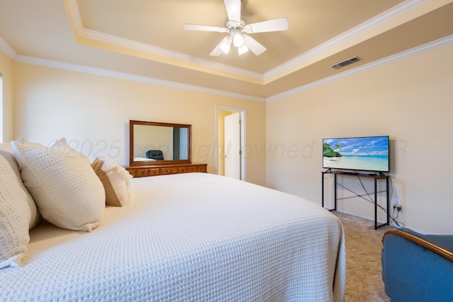 bedroom featuring visible vents, ornamental molding, a tray ceiling, carpet floors, and ceiling fan