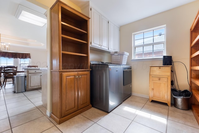 laundry room with cabinet space, independent washer and dryer, light tile patterned flooring, and a healthy amount of sunlight