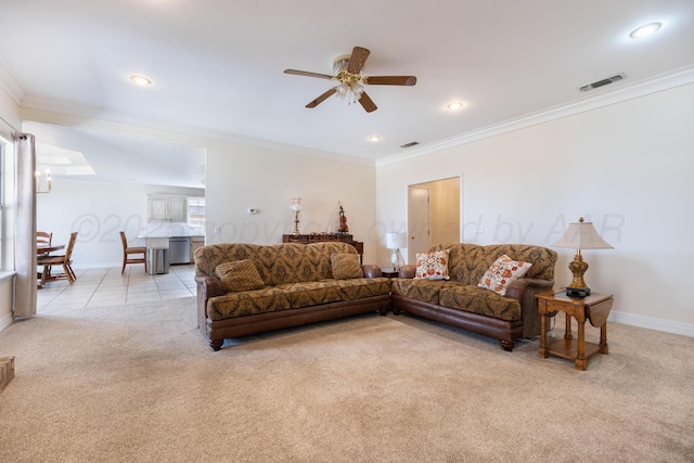 living area featuring a ceiling fan, light colored carpet, visible vents, and ornamental molding