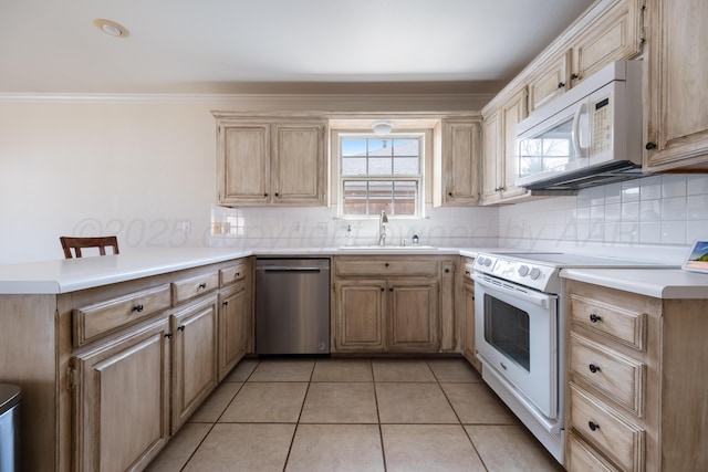 kitchen with white appliances, a peninsula, a sink, crown molding, and backsplash