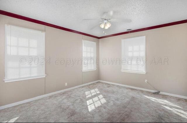 carpeted spare room with baseboards, ceiling fan, ornamental molding, and a textured ceiling